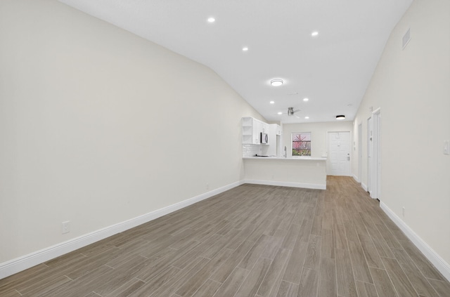 8583 Overset Ln Unit C, Boca Raton, FL 33496 - unfurnished living room with light wood-type flooring, lofted ceiling, and recessed lighting