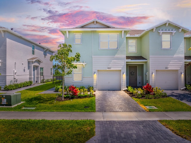 663 SE Lake Falls St, Port Saint Lucie, FL 34984 - multi unit property featuring an attached garage, decorative driveway, and a lawn