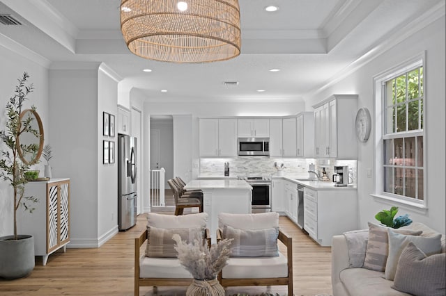 17564 Cinquez Park Rd W, Jupiter, FL 33458 - kitchen with stainless steel appliances, a tray ceiling, backsplash, a sink, and crown molding