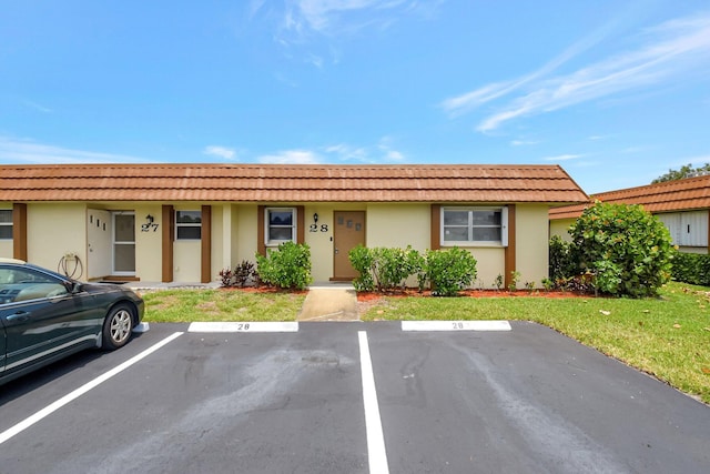 5730 Fernley Dr E Unit 28, West Palm Beach, FL 33415 - townhome / multi-family property with uncovered parking, stucco siding, a tile roof, and a front lawn