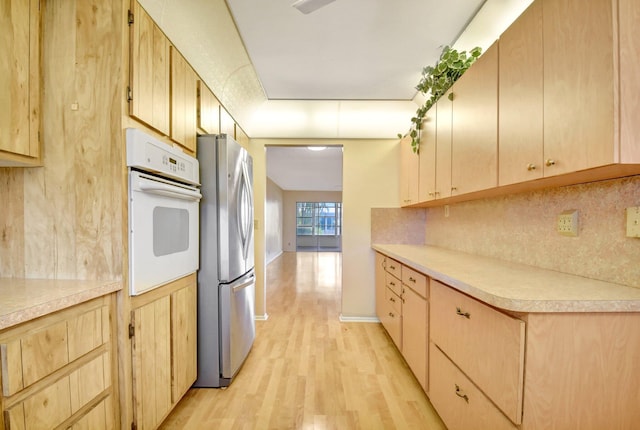 5730 Fernley Dr E Unit 28, West Palm Beach, FL 33415 - kitchen with freestanding refrigerator, white oven, light brown cabinets, and light wood-style floors