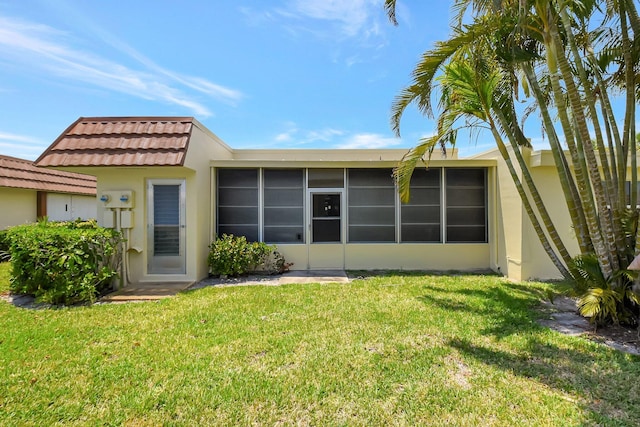 5730 Fernley Dr E Unit 28, West Palm Beach, FL 33415 - back of house with stucco siding, a sunroom, a yard, and a tiled roof
