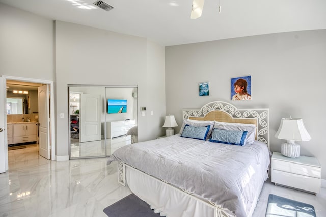 208 Legendary Cir, Palm Beach Gardens, FL 33418 - bedroom with marble tiled flooring, a high ceiling, a closet, ensuite bath, and baseboards
