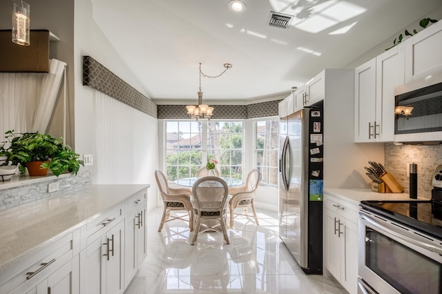 208 Legendary Cir, Palm Beach Gardens, FL 33418 - kitchen with stainless steel appliances, backsplash, a chandelier, lofted ceiling, and white cabinets