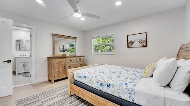 218 NE 10th St, Delray Beach, FL 33444 - bedroom with light wood-type flooring, recessed lighting, a sink, connected bathroom, and baseboards