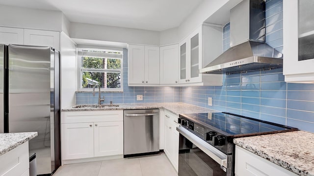 218 NE 10th St, Delray Beach, FL 33444 - kitchen featuring stainless steel appliances, wall chimney exhaust hood, a sink, tasteful backsplash, and light stone counters