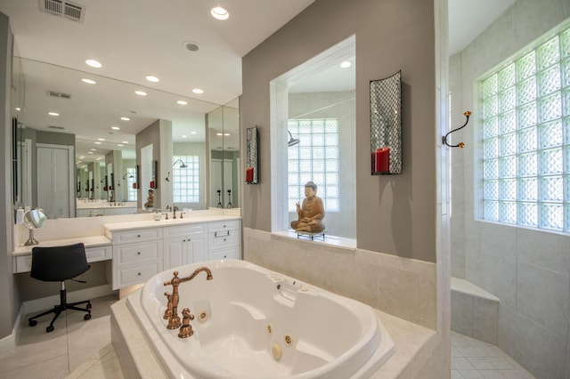bathroom featuring tile patterned floors, a tub with jets, plenty of natural light, and recessed lighting