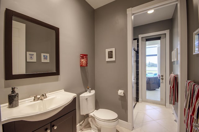 bathroom featuring baseboards, toilet, vanity, and tile patterned flooring