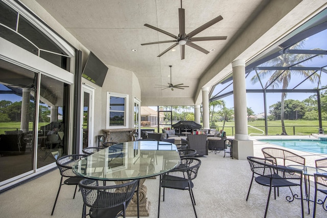 view of patio featuring ceiling fan, an outdoor pool, outdoor dining area, and glass enclosure
