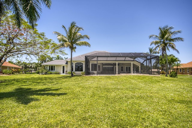 rear view of property featuring a lawn and a lanai