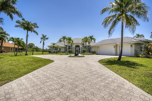 view of front facade featuring decorative driveway, stucco siding, a garage, a front yard, and a tile roof