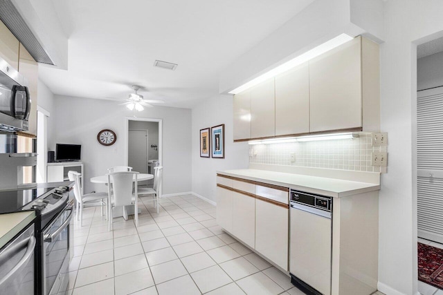 65 Eastgate Dr Unit B, Boynton Beach, FL 33436 - kitchen featuring ceiling fan, backsplash, light countertops, appliances with stainless steel finishes, and white cabinetry
