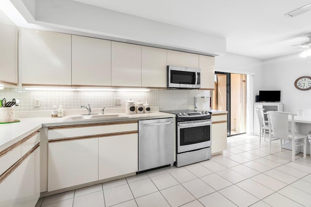 65 Eastgate Dr Unit B, Boynton Beach, FL 33436 - kitchen featuring appliances with stainless steel finishes, a sink, decorative backsplash, light countertops, and white cabinetry
