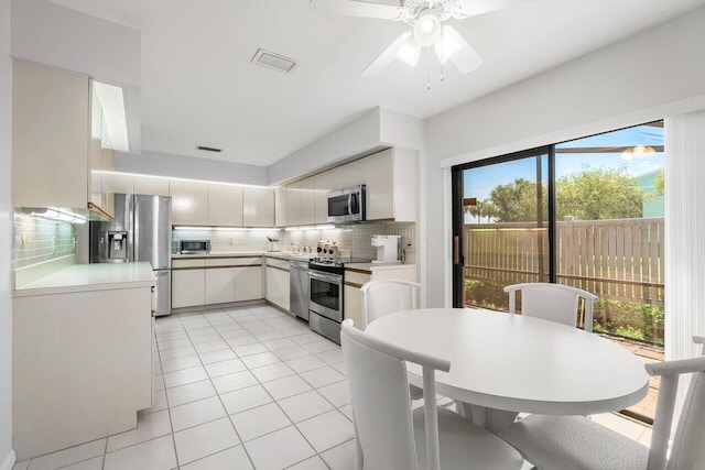 65 Eastgate Dr Unit B, Boynton Beach, FL 33436 - kitchen featuring appliances with stainless steel finishes, tasteful backsplash, light countertops, light tile patterned flooring, and a ceiling fan