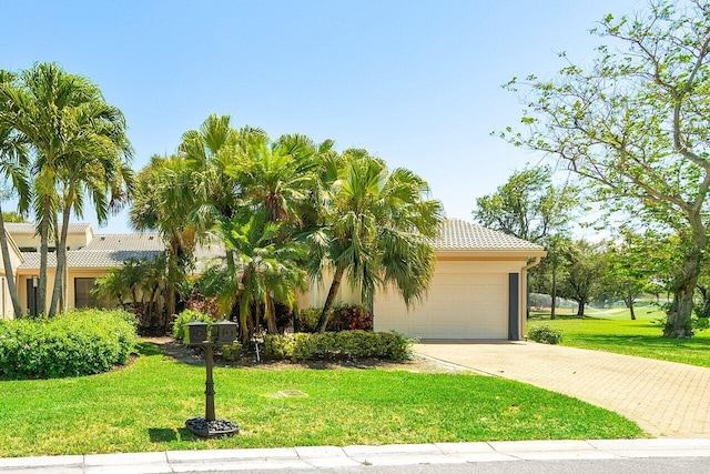 65 Eastgate Dr Unit B, Boynton Beach, FL 33436 - view of front of home featuring driveway, a front yard, a garage, a tile roof, and stucco siding