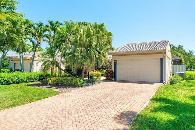 65 Eastgate Dr Unit B, Boynton Beach, FL 33436 - view of front of home featuring a front yard, stucco siding, decorative driveway, an attached garage, and a tile roof