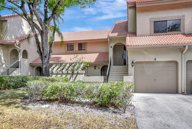 5640 Coach House Cir Unit C, Boca Raton, FL 33486 - mediterranean / spanish-style house featuring a tile roof, stucco siding, and asphalt driveway