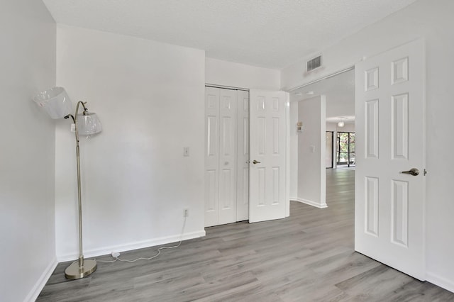5640 Coach House Cir Unit C, Boca Raton, FL 33486 - unfurnished bedroom featuring light wood-style floors, baseboards, a closet, and a textured ceiling