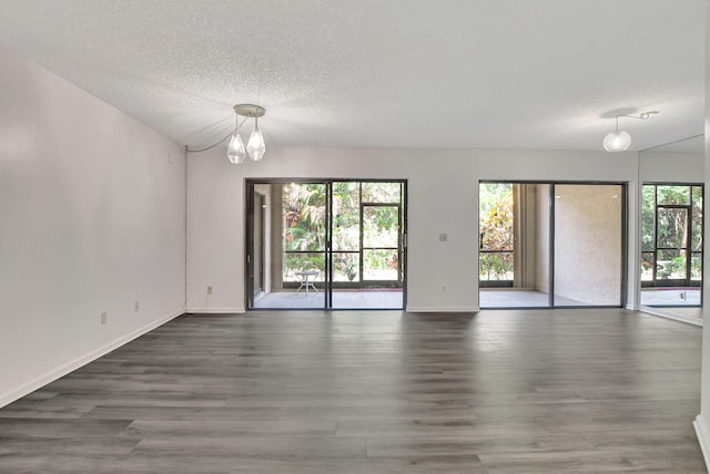 5640 Coach House Cir Unit C, Boca Raton, FL 33486 - empty room featuring a textured ceiling, wood finished floors, baseboards, and a chandelier
