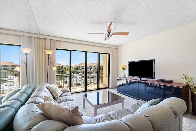 1401 Tidal Pointe Blvd Unit 405, Jupiter, FL 33477 - carpeted living area featuring a textured ceiling and a ceiling fan