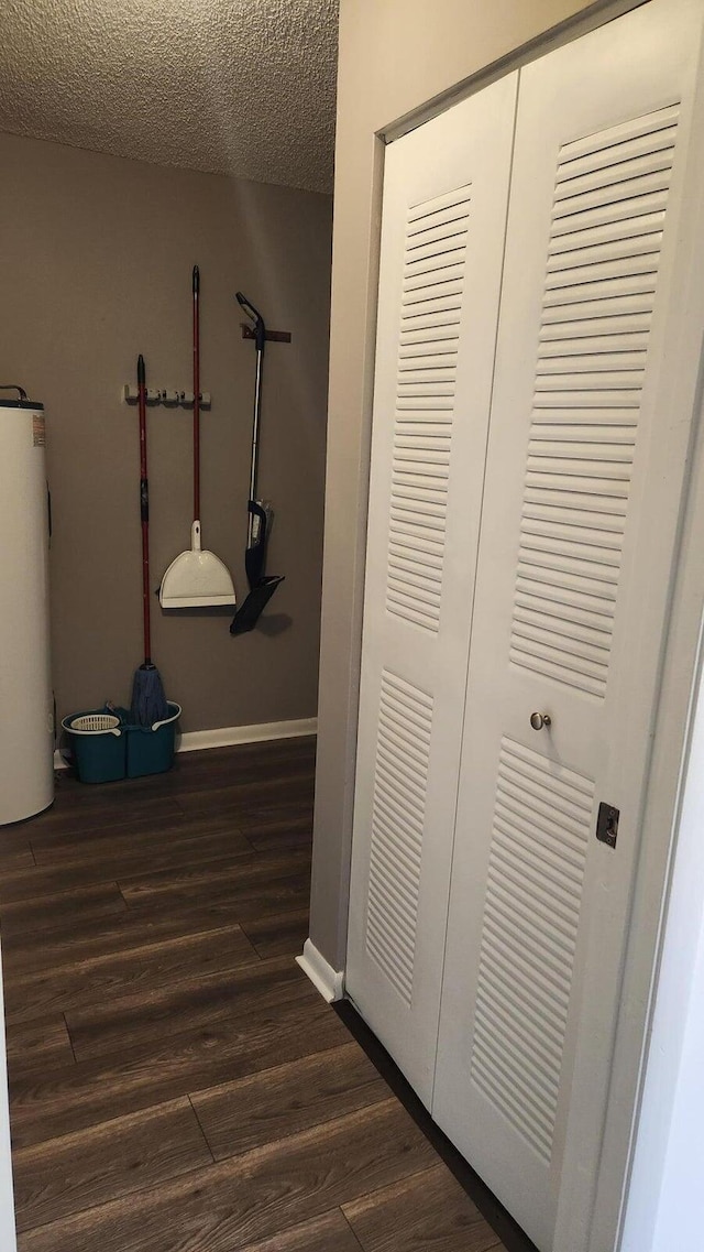 164 Meadows Dr, Boynton Beach, FL 33436 - hallway featuring water heater, dark wood finished floors, and a textured ceiling