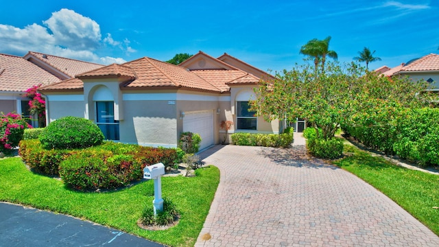 6179 Evian Pl, Boynton Beach, FL 33437 - mediterranean / spanish house with an attached garage, stucco siding, a tile roof, decorative driveway, and a front lawn