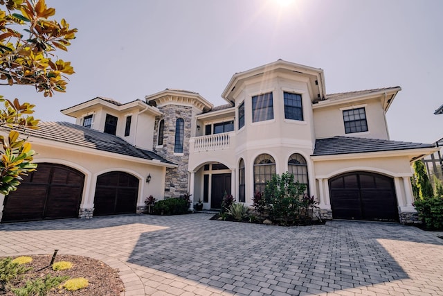 8979 Three Rail Dr, Boynton Beach, FL 33472 - view of front of house featuring a balcony, stucco siding, decorative driveway, stone siding, and a tiled roof