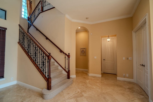8979 Three Rail Dr, Boynton Beach, FL 33472 - foyer entrance featuring arched walkways, ornamental molding, stairway, and baseboards