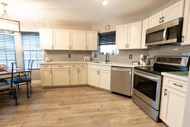 1325 Strawberry Ln, West Palm Beach, FL 33415 - kitchen featuring stainless steel appliances, a sink, light countertops, backsplash, and a textured ceiling
