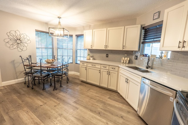 1325 Strawberry Ln, West Palm Beach, FL 33415 - kitchen featuring stainless steel appliances, a sink, a chandelier, tasteful backsplash, and baseboards