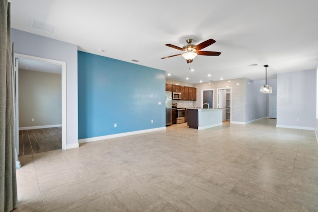 852 Gairloch Ln, Fort Pierce, FL 34947 - unfurnished living room with ceiling fan, baseboards, recessed lighting, light tile patterned floors, and a sink