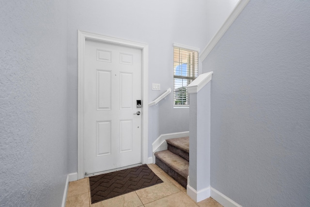 852 Gairloch Ln, Fort Pierce, FL 34947 - entrance foyer with a textured wall, baseboards, light tile patterned floors, and stairway