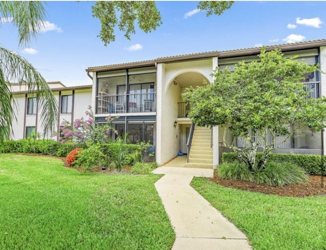 2114 SW Silver Pine Way Unit 121-C1, Palm City, FL 34990 - view of property with stucco siding, a front yard, and stairway