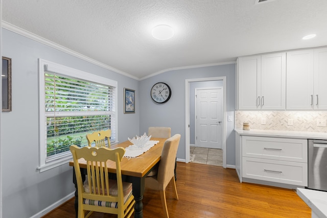 454 Tequesta Dr, Tequesta, FL 33469 - dining space with ornamental molding, light wood-type flooring, a textured ceiling, and baseboards