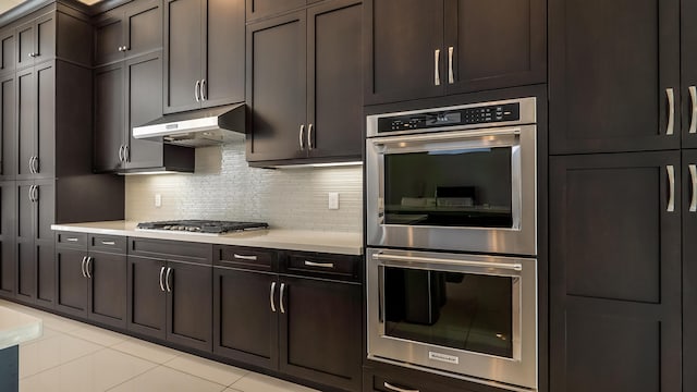 8520 Lewis River Rd, Delray Beach, FL 33446 - kitchen featuring stainless steel appliances, under cabinet range hood, light countertops, tasteful backsplash, and light tile patterned floors