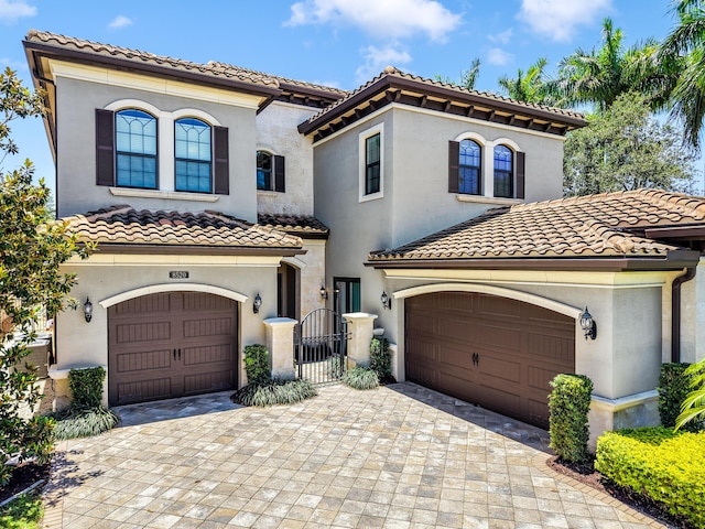 8520 Lewis River Rd, Delray Beach, FL 33446 - mediterranean / spanish house featuring a tile roof, stucco siding, a garage, and decorative driveway