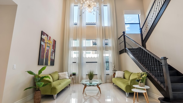 8520 Lewis River Rd, Delray Beach, FL 33446 - living room featuring a towering ceiling, a chandelier, stairway, baseboards, and tile patterned floors