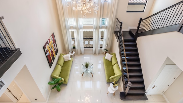 8520 Lewis River Rd, Delray Beach, FL 33446 - stairs with tile patterned floors, a high ceiling, a chandelier, and baseboards