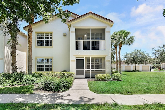 174 SE Kitching Cir Unit 174, Stuart, FL 34994 - view of front of home with stucco siding, a front yard, and a tile roof