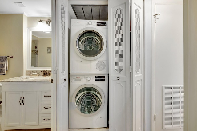 1800 SE Saint Lucie Blvd Unit 2-204, Stuart, FL 34996 - washroom with stacked washer / dryer and ornamental molding