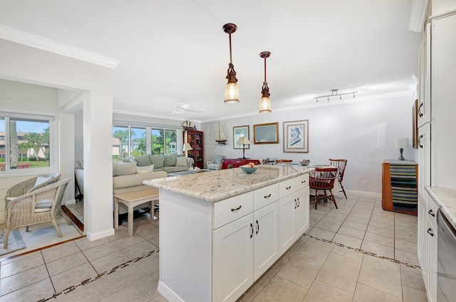 1800 SE Saint Lucie Blvd Unit 2-204, Stuart, FL 34996 - kitchen with ornamental molding, light tile patterned flooring, white cabinetry, decorative light fixtures, and a center island