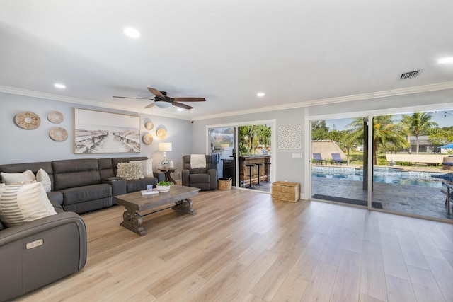 living area featuring ornamental molding, ceiling fan, light wood-style floors, and recessed lighting