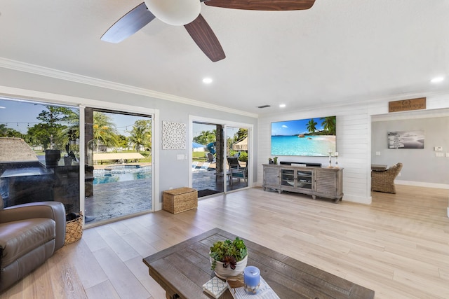 living room featuring crown molding, ceiling fan, wood finished floors, baseboards, and recessed lighting