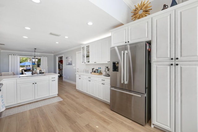 kitchen with stainless steel fridge, crown molding, a sink, recessed lighting, and white cabinets
