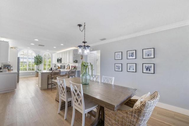 dining room with light wood-style floors, baseboards, recessed lighting, ornamental molding, and a chandelier