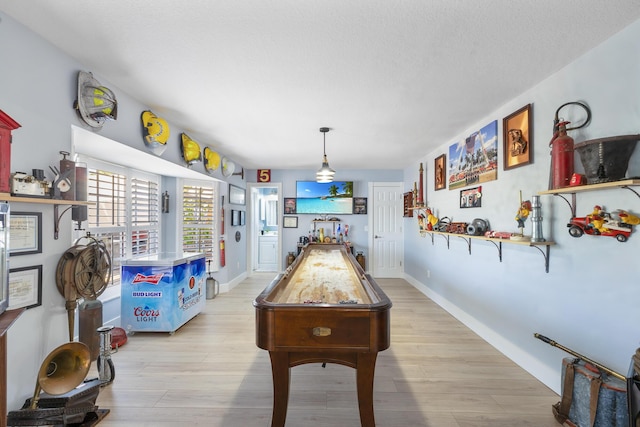 recreation room featuring light wood-style floors and baseboards