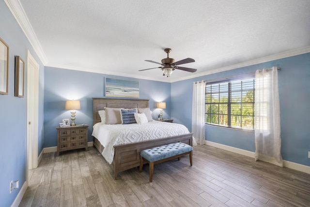 bedroom featuring wood finished floors, baseboards, ornamental molding, ceiling fan, and a textured ceiling