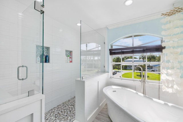 bathroom with walk in shower, ornamental molding, a freestanding bath, and recessed lighting