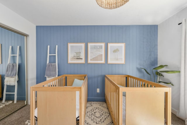 carpeted bedroom with a nursery area and baseboards