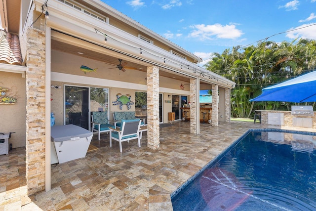 swimming pool featuring a patio area, ceiling fan, and exterior bar
